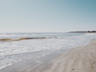 A serene beach with gentle waves and soft sand.
