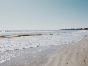 A serene beach in Bénin with gentle waves lapping at the sandy shore.