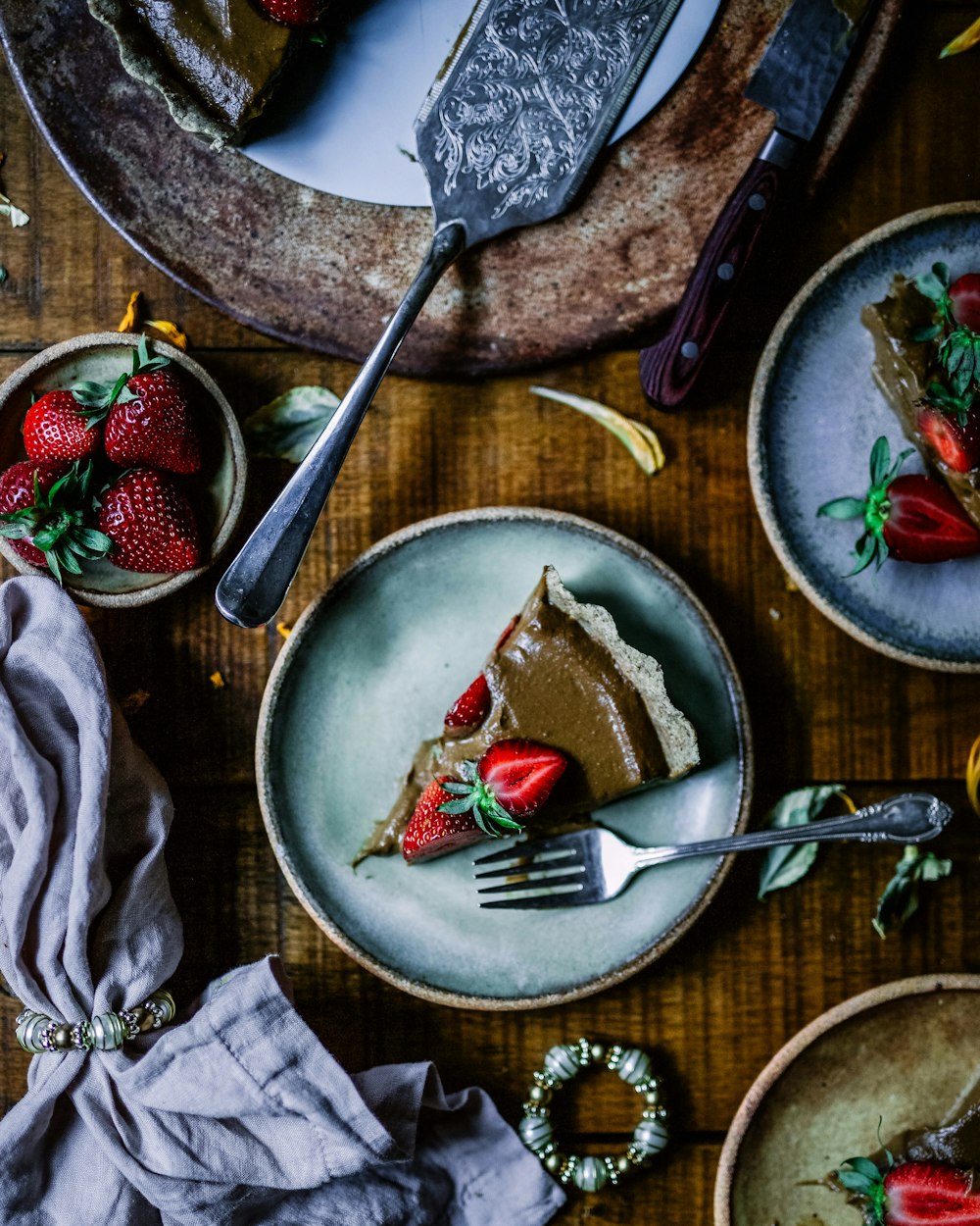 Morceau de gâteau servi sur une assiette ronde en céramique grise