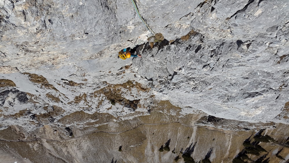 a man climbing up the side of a mountain