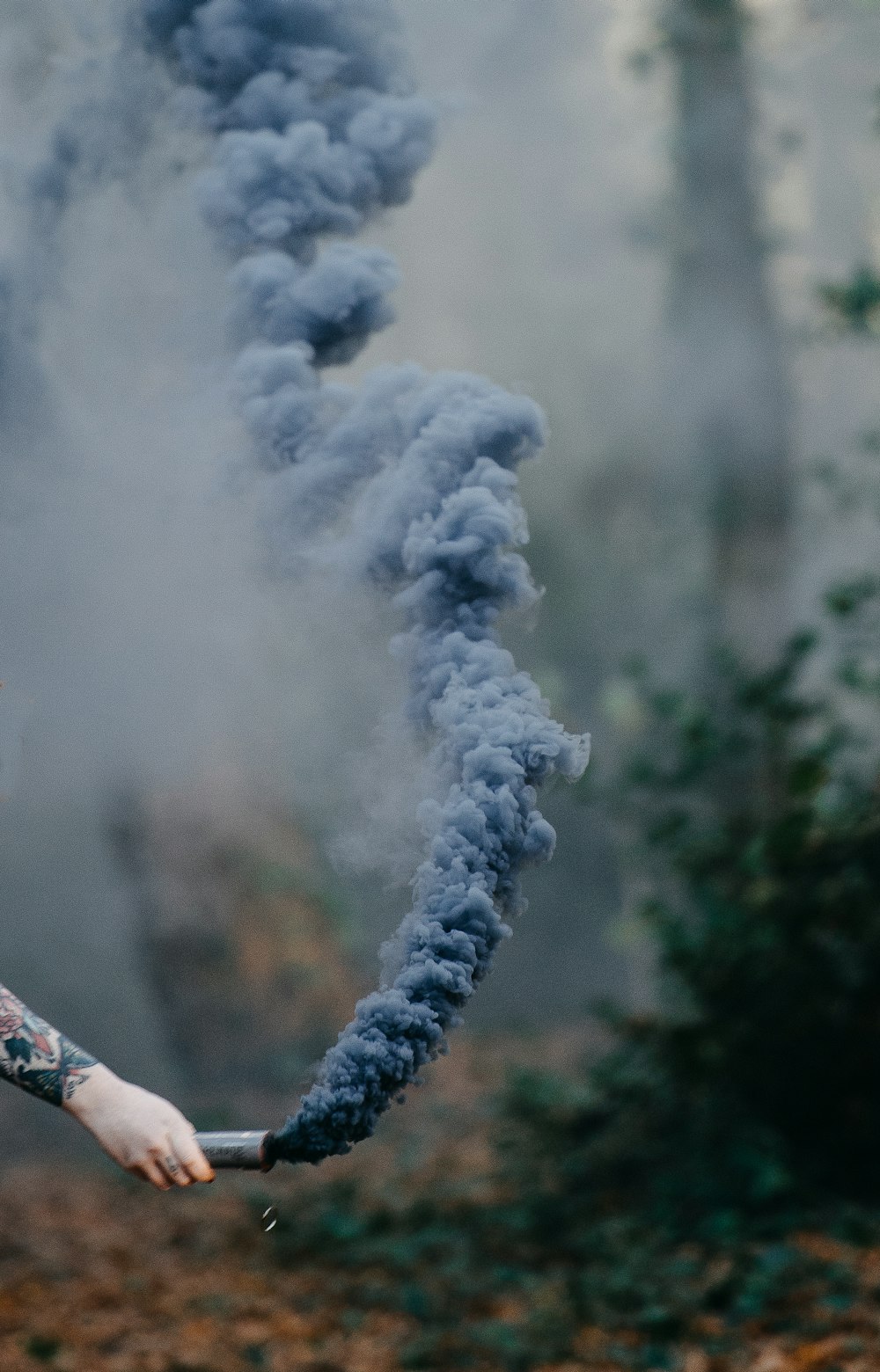 a person holding a smoke bomb in their hand