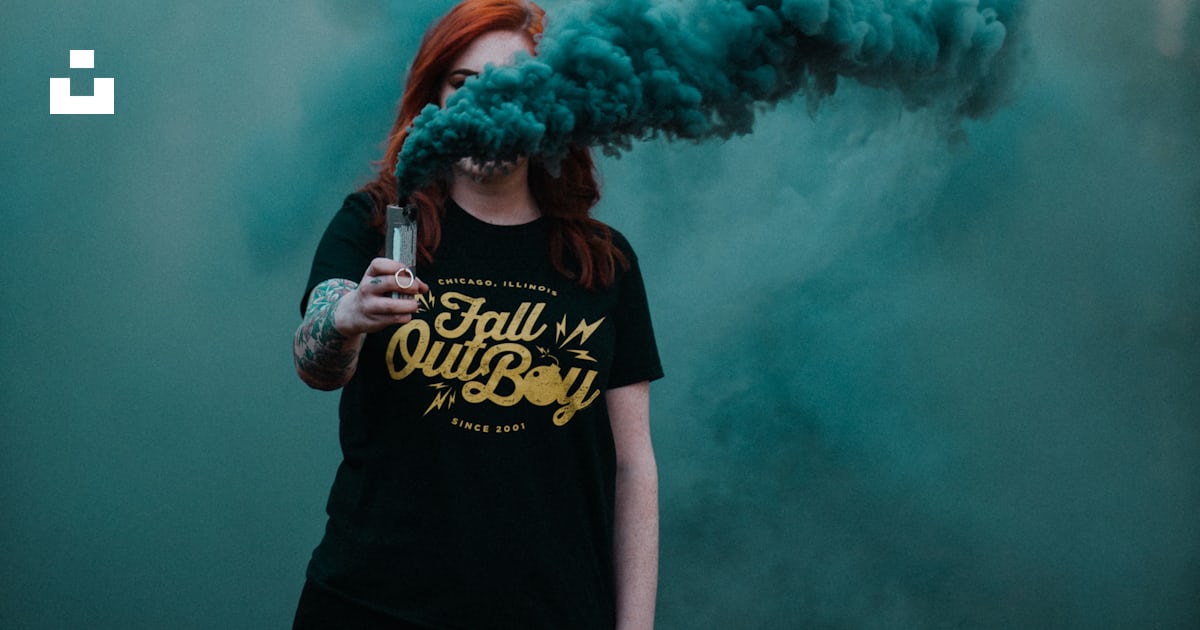 Woman holding vaporizer releasing blue smoke near forest photo – Free ...