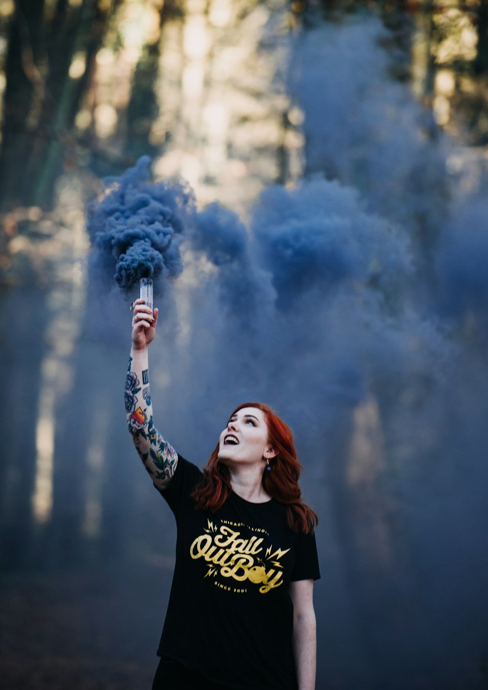 Mujer sosteniendo una señal de humo azul