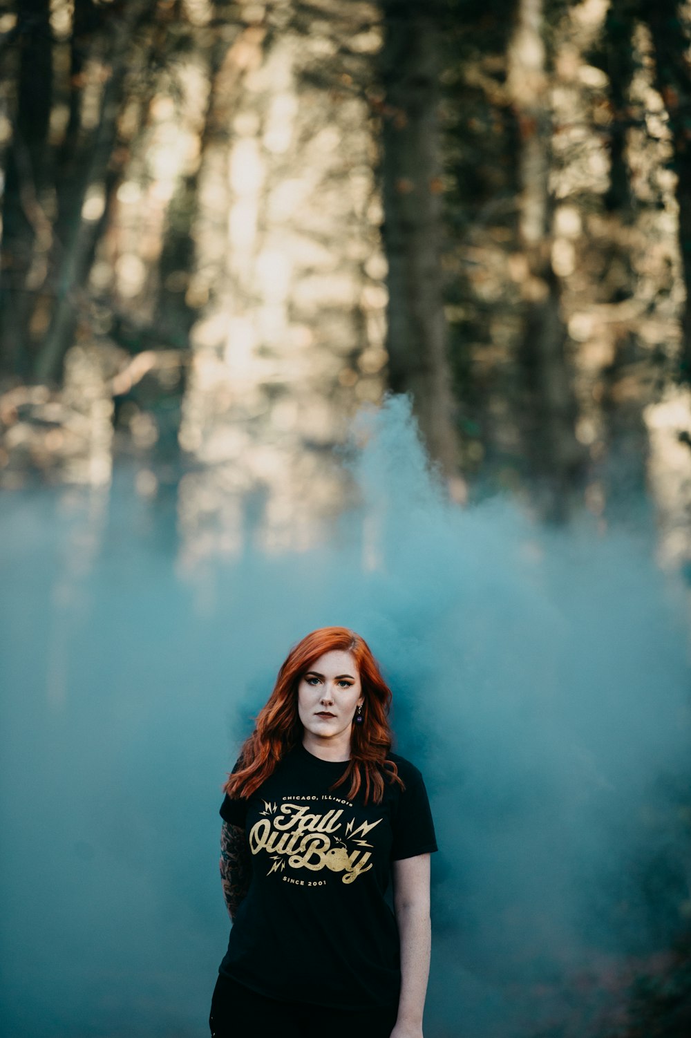 woman in black t-shirt with teal smoke in selective focus photography
