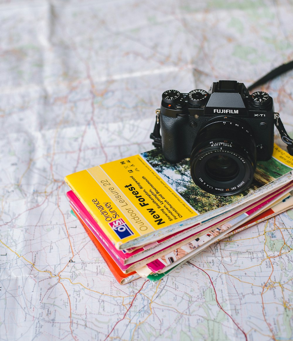 black Fujifilm DSLR camera on books