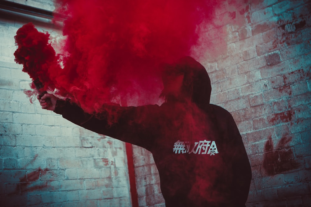 person holding red smoke bonb