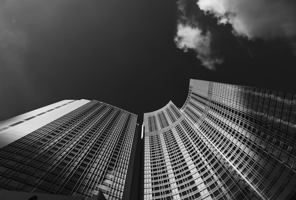 Dramatic low-key photograph of glass skyscrapers reflecting a night cityscape.