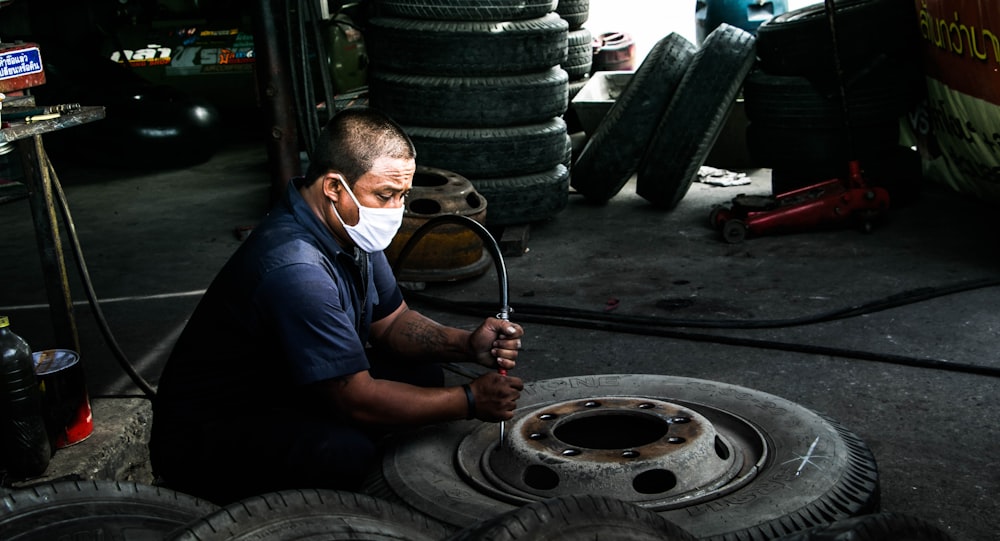 man airing up wheel during daytime