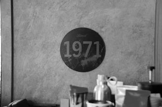 A vintage black-and-white photograph of the original Chekkuppa Traders storefront, capturing the humble beginnings in 1955.