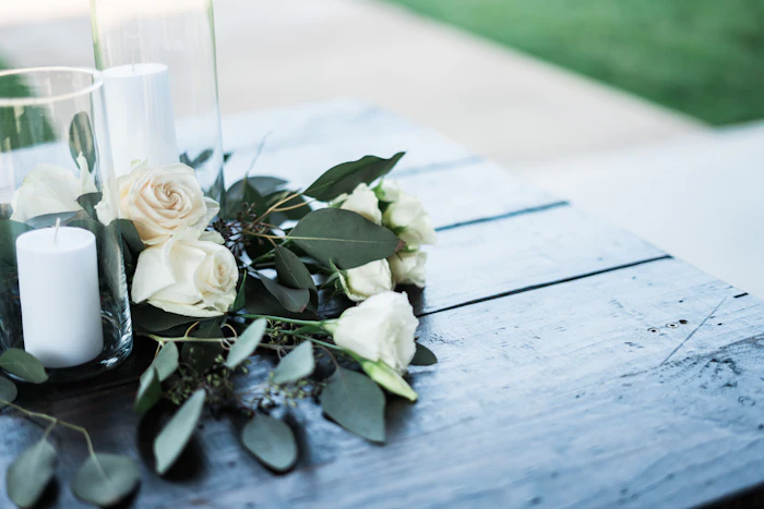 Rosas blancas y amarillas junto a una columna