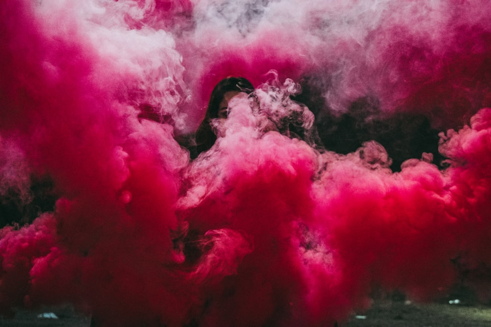 femme couverte d’une bombe fumigène rose