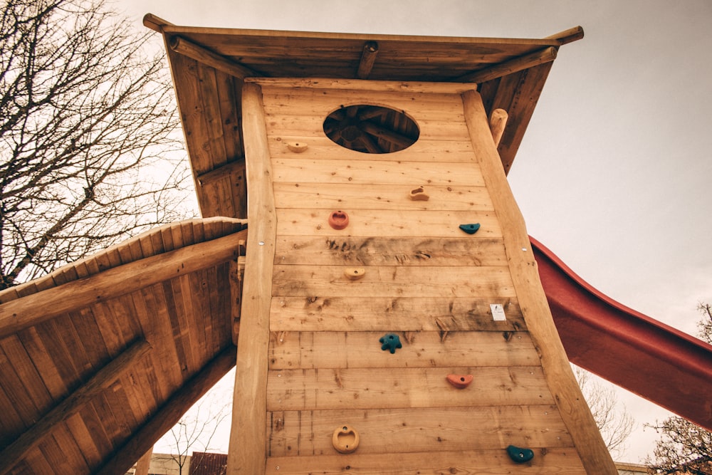 brown wooden house with red slide