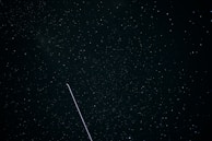 A night sky filled with stars and a digital network overlay representing AI connections.