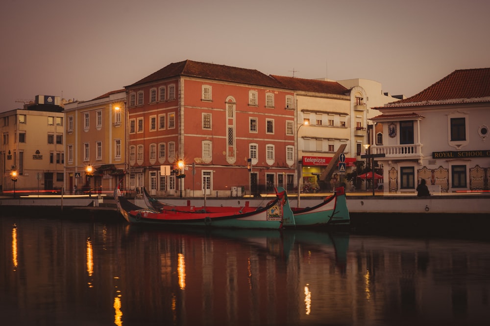 Blaugrünes und rotes Boot auf dem Fluss unter grauem Himmel