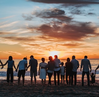 people standing on shore during golden hour