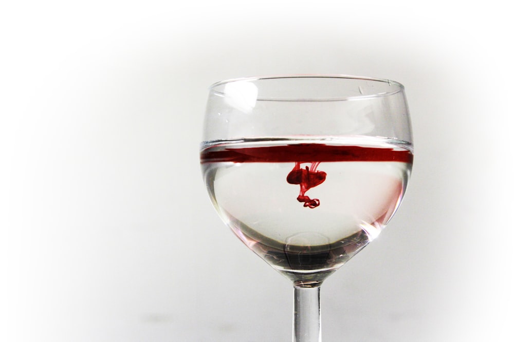 clear wine glass filled with red liquid