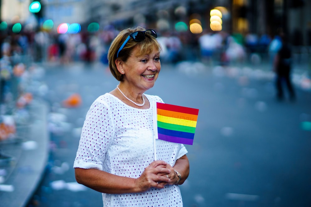 mulher sorrindo segurando bandeira LGBT