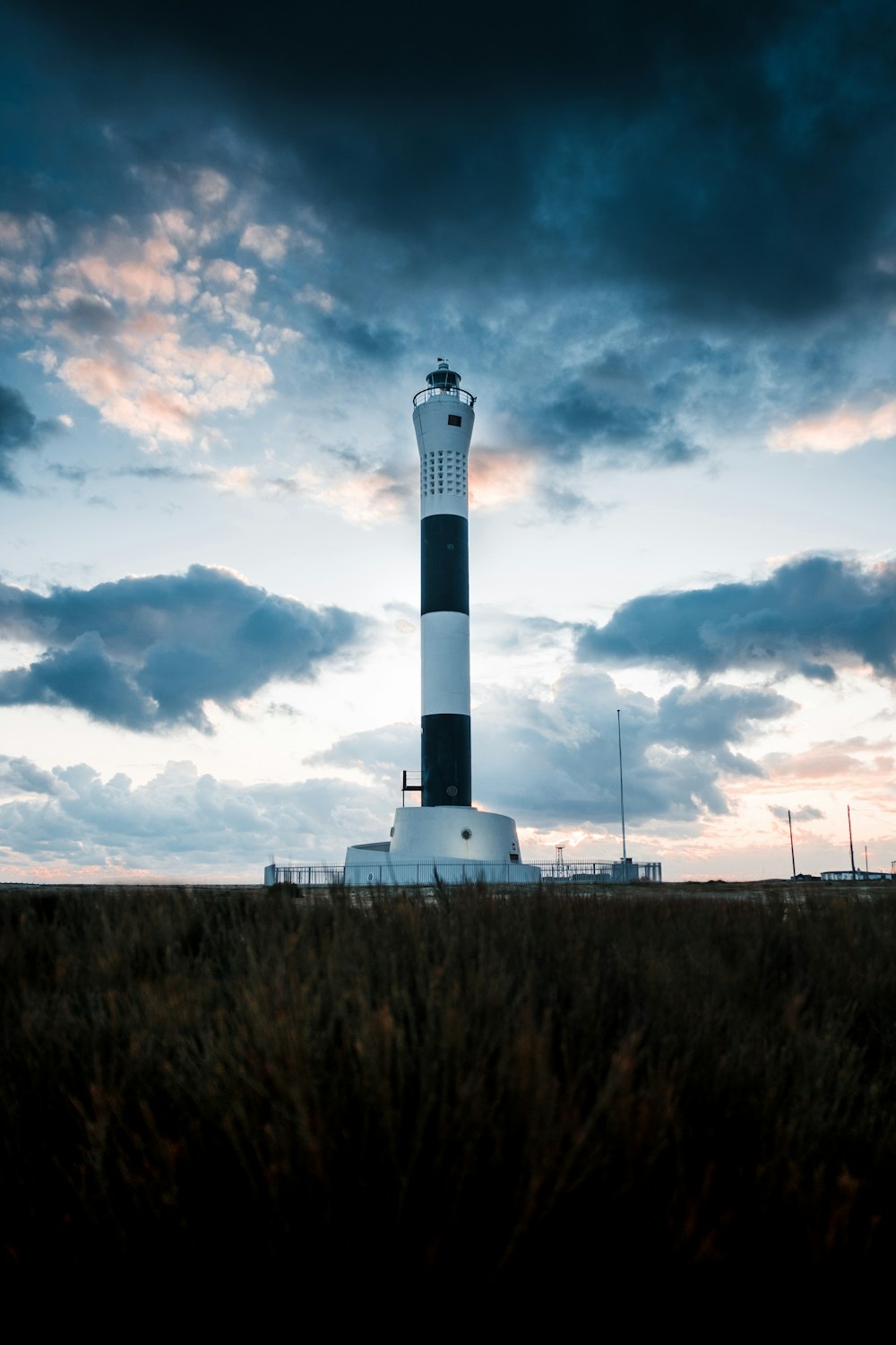 white light house near grass field