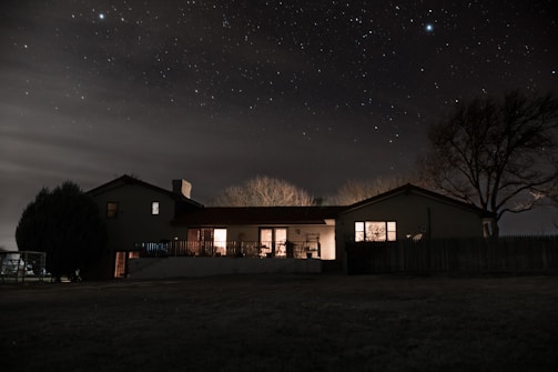 A nighttime shot of a house with newly installed windows glowing warmly inside.