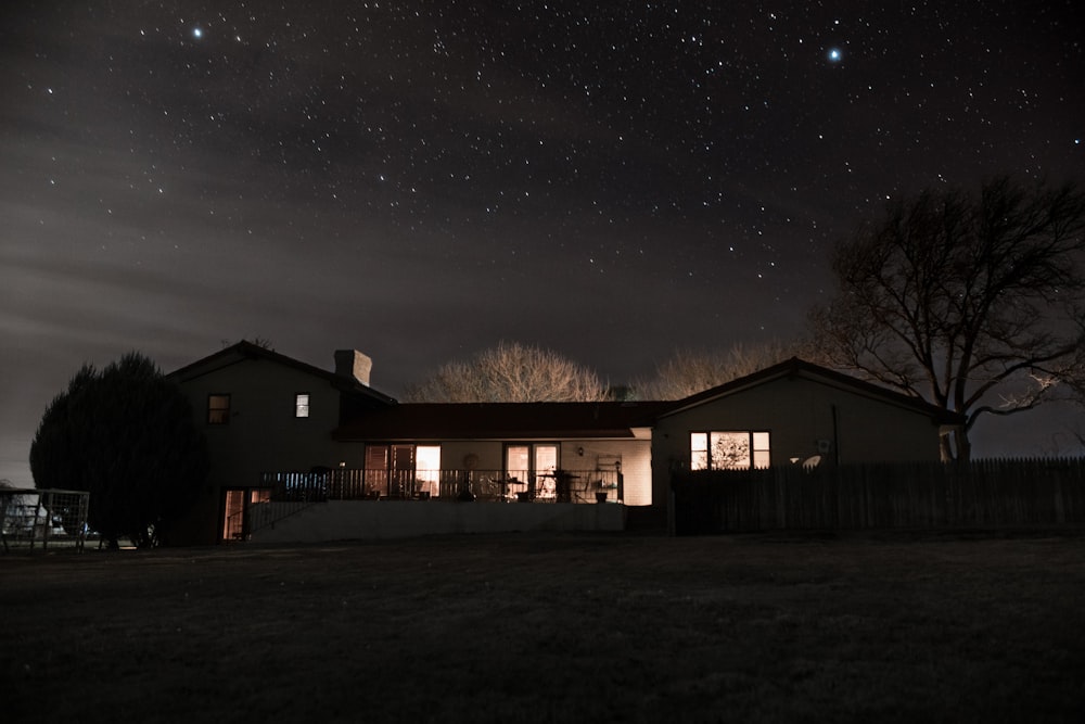 landscape photography of a house under nightsky