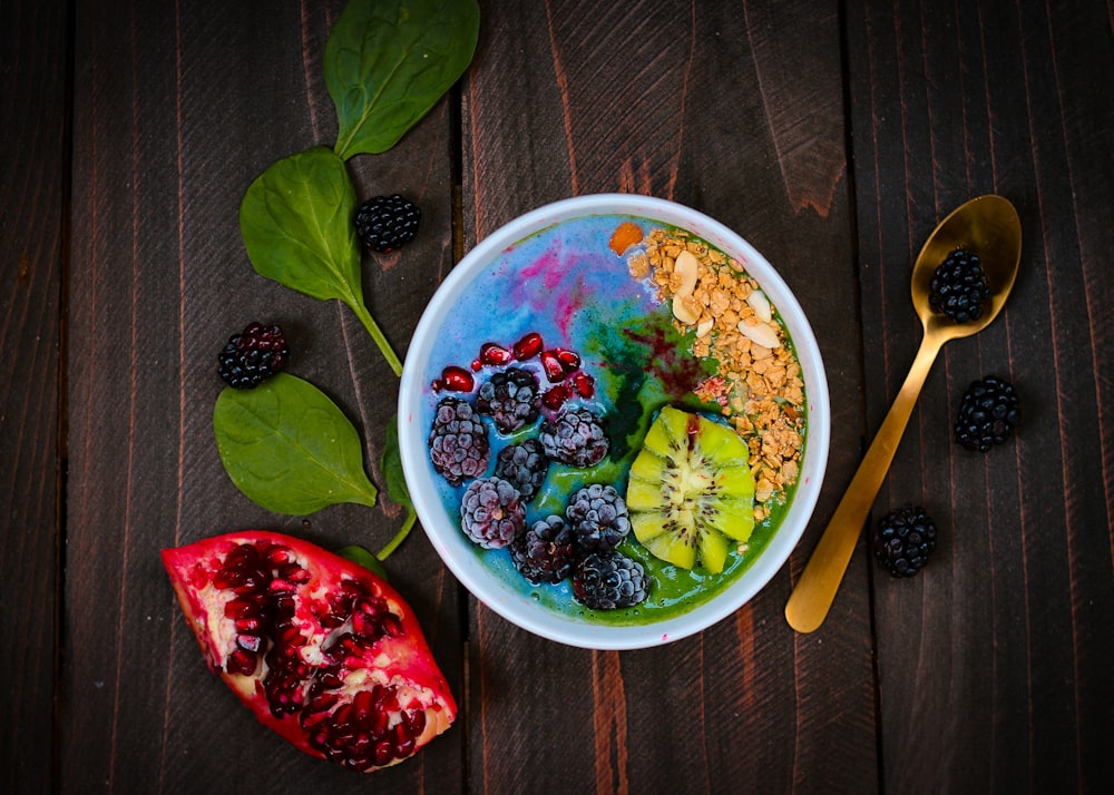 mixed fruits on bowl with blueberry on top