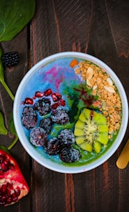 mixed fruits on bowl with blueberry on top