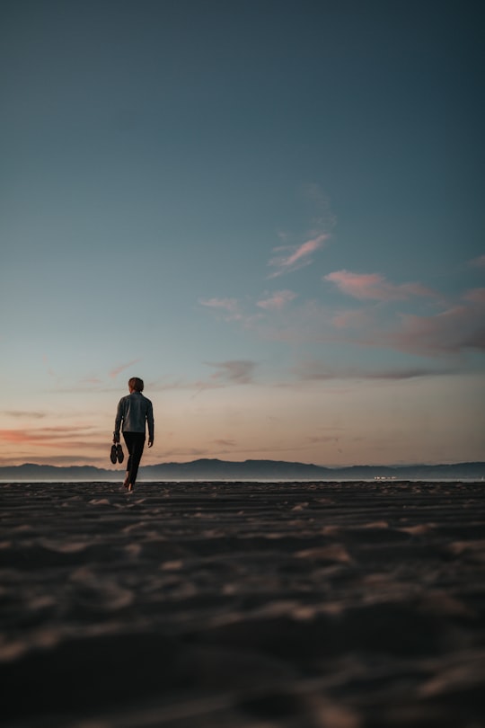 man walking on sand while holding his footwears in Redondo Beach United States