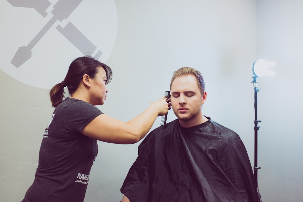 mujer cortando el pelo del hombre