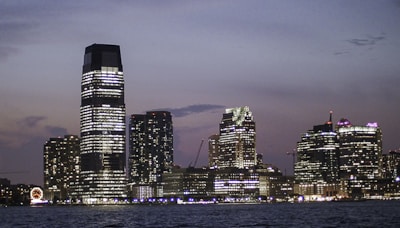City skyline glowing with lights against a twilight sky.