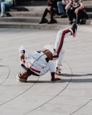 man doing bboy in front of people at daytime