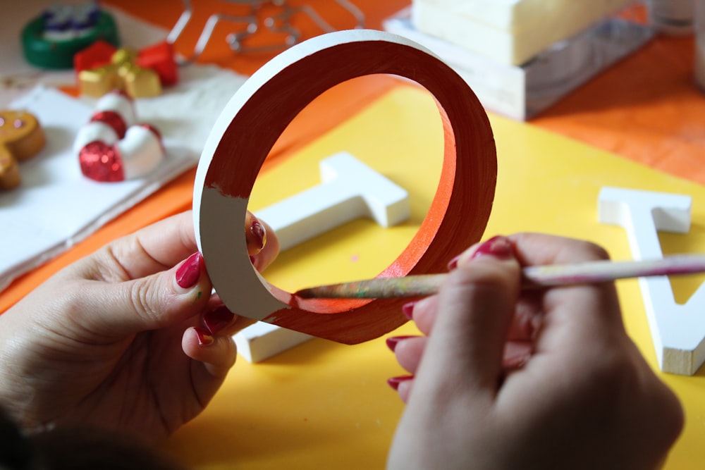 person painting red freestanding letter