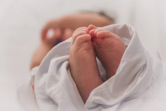 baby covered with white blanket
