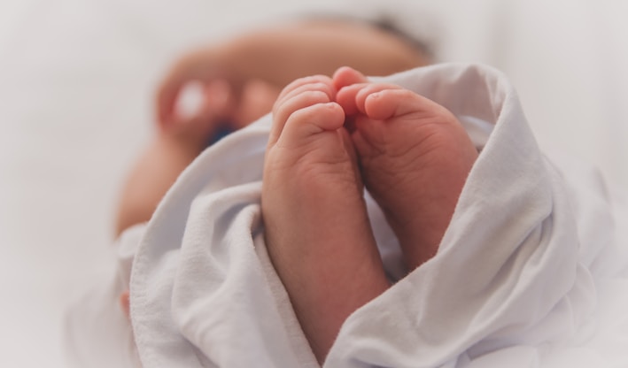 baby covered with white blanket