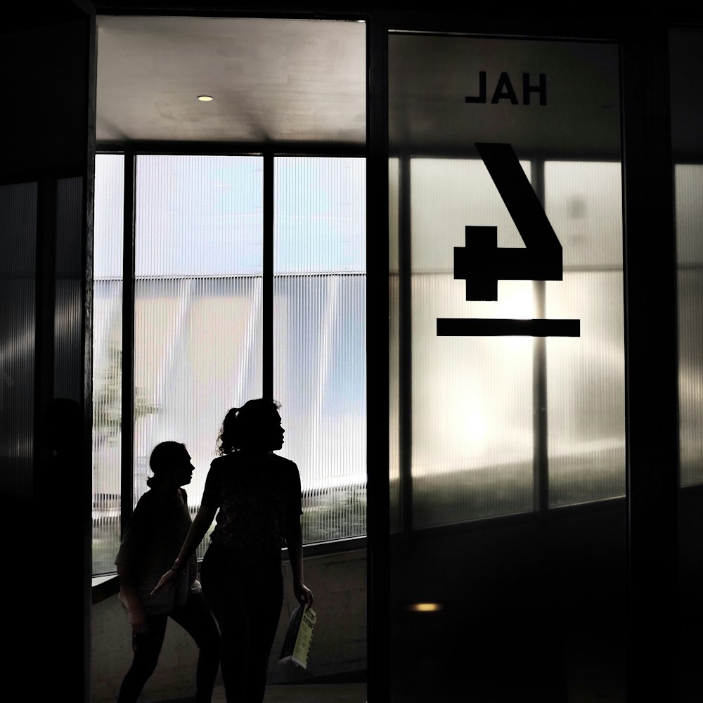 two woman walking through door