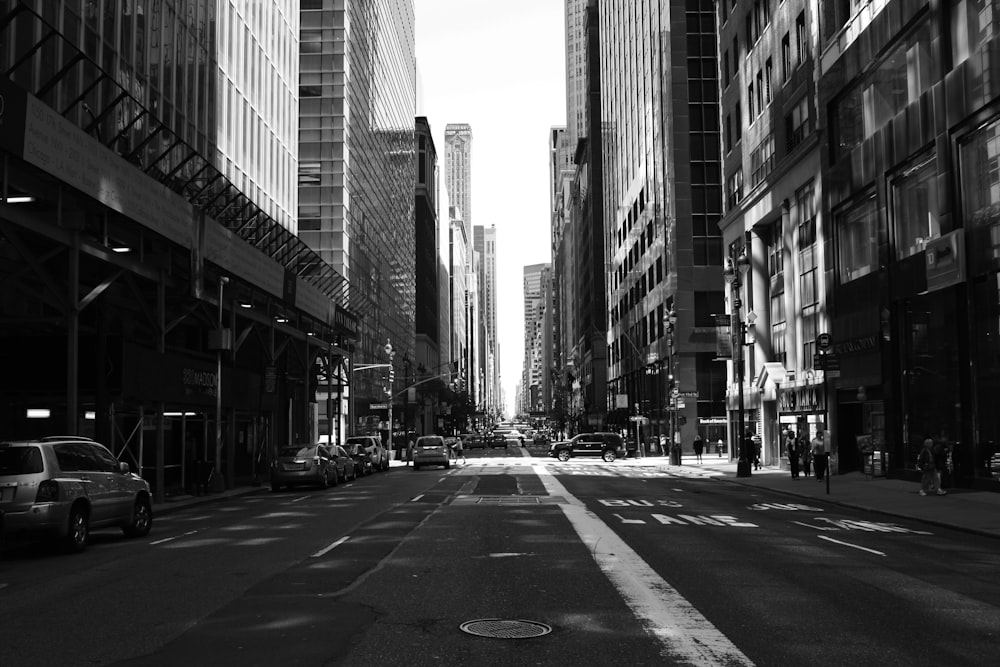 grayscale photography of road between buildings