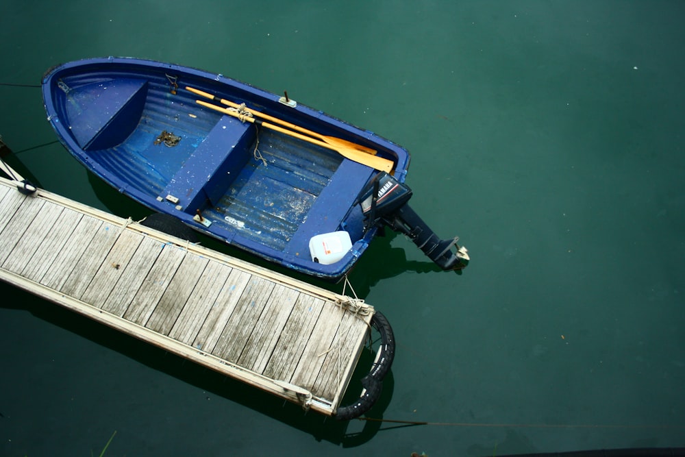 Blaues Jon-Boot neben beigefarbenem Dock