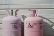 two pink Dynatemp 410 tanks on front of white wall