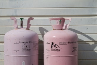 two pink Dynatemp 410 tanks on front of white wall