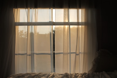 Soft sunlight filtering through sheer curtains in a cozy relaxation space.