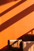a chair sitting in front of an orange wall