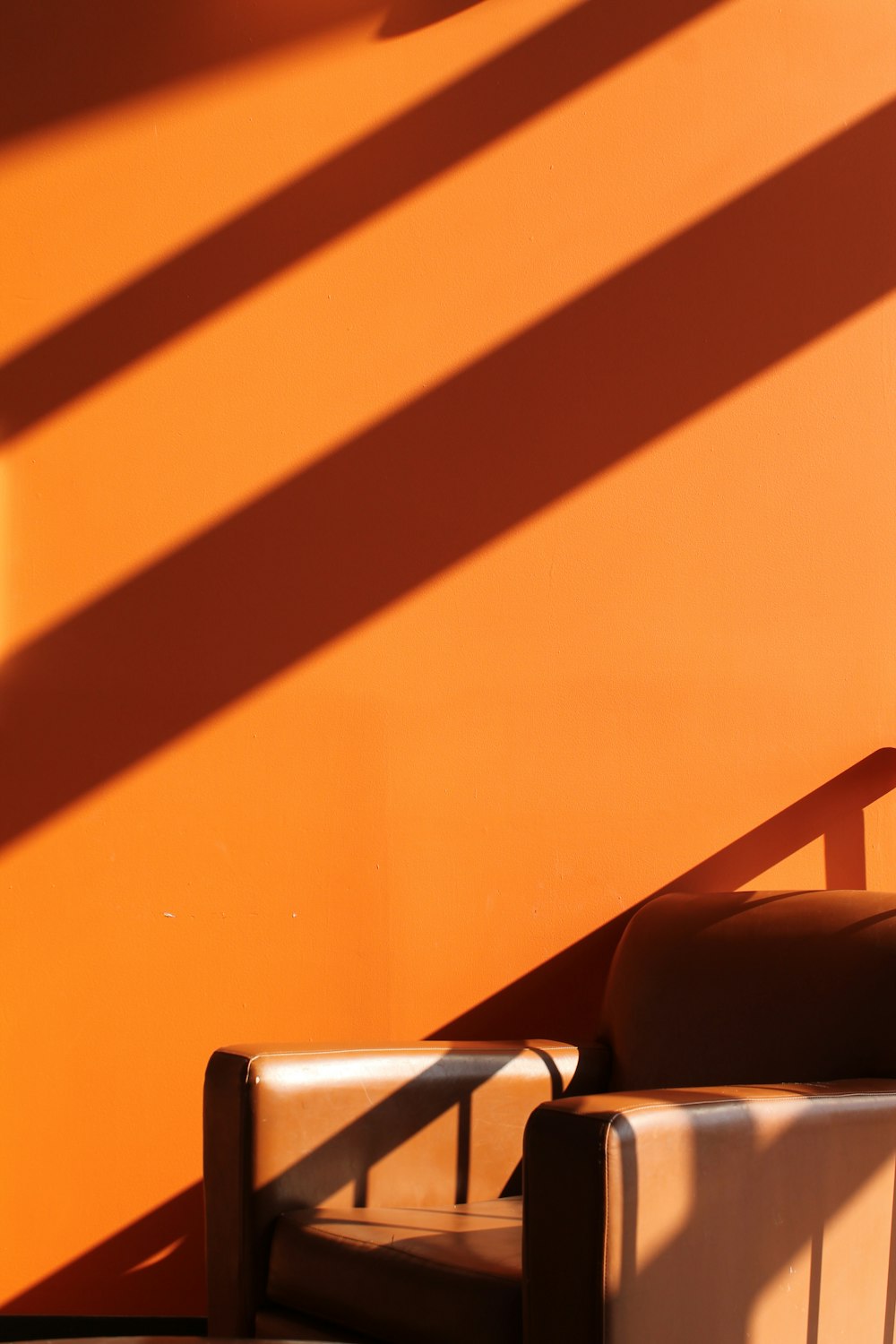 a chair sitting in front of an orange wall