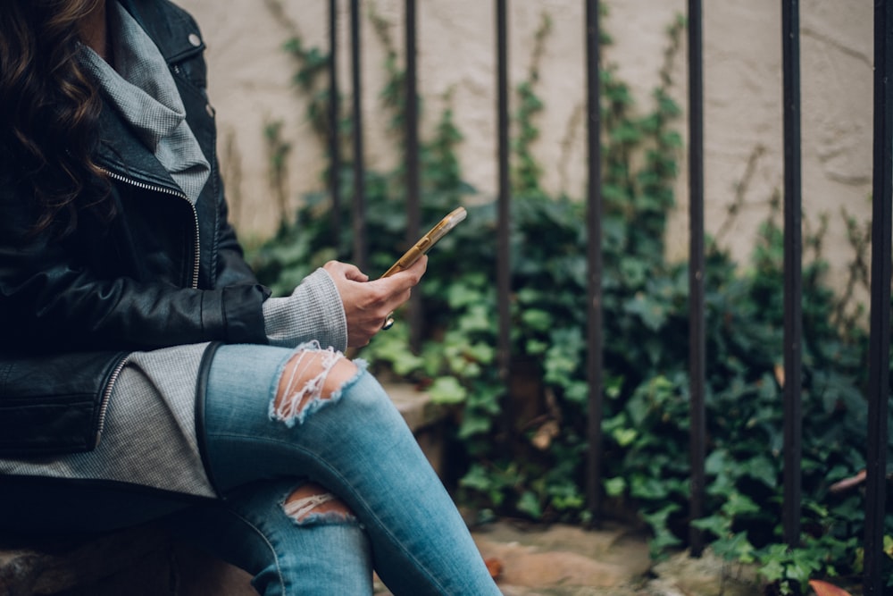 Mujer usando un teléfono inteligente dorado