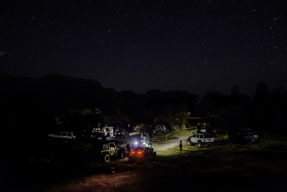 a group of trucks parked on top of a grass covered field