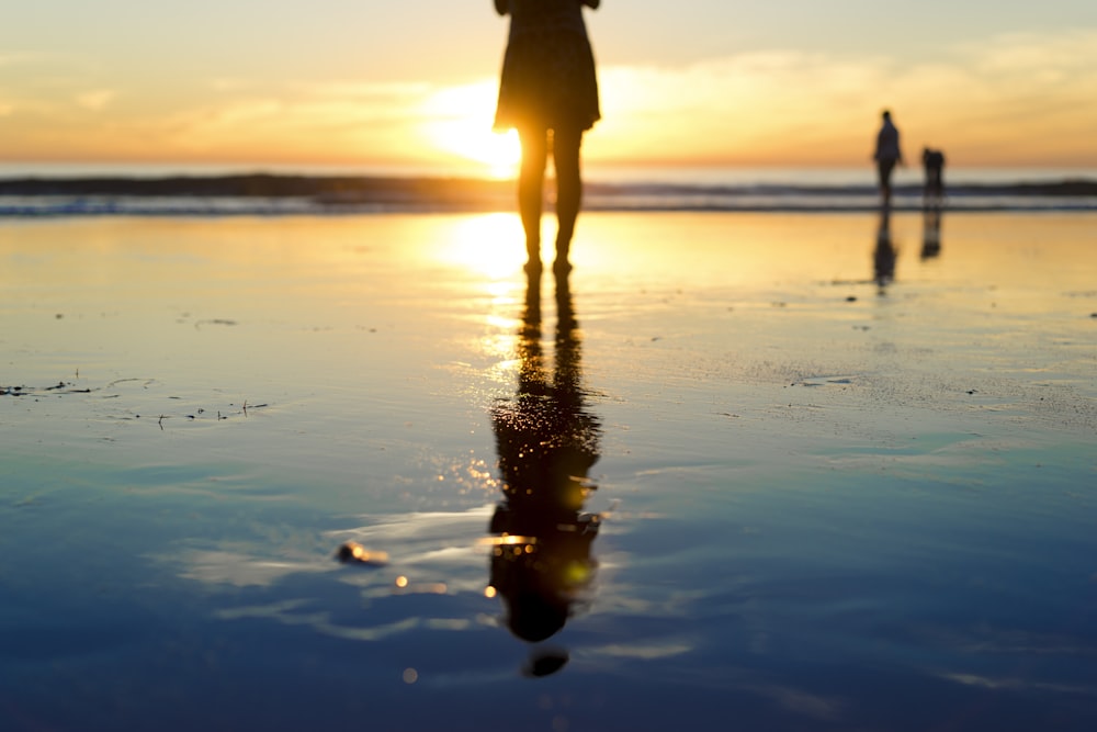 Silhouette einer Frau am Strand während der goldenen Stunde