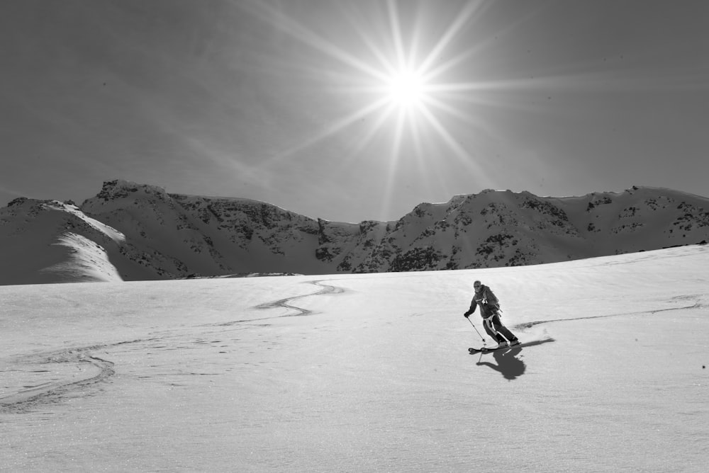 雪山でスキーをする人のグレースケール写真