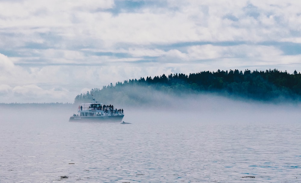 landscape photography of boat sailing near islet