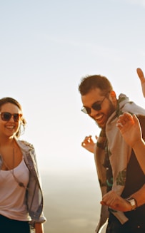 three men and one woman laughing during daytime