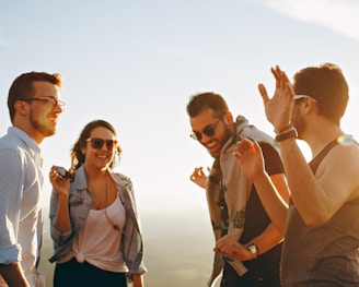 three men and one woman laughing during daytime