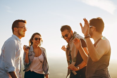 three men and one woman laughing during daytime joyful google meet background