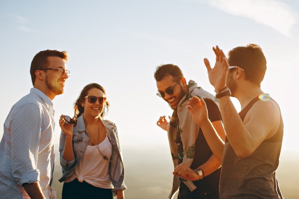 Drei Männer und eine Frau, die tagsüber lachen